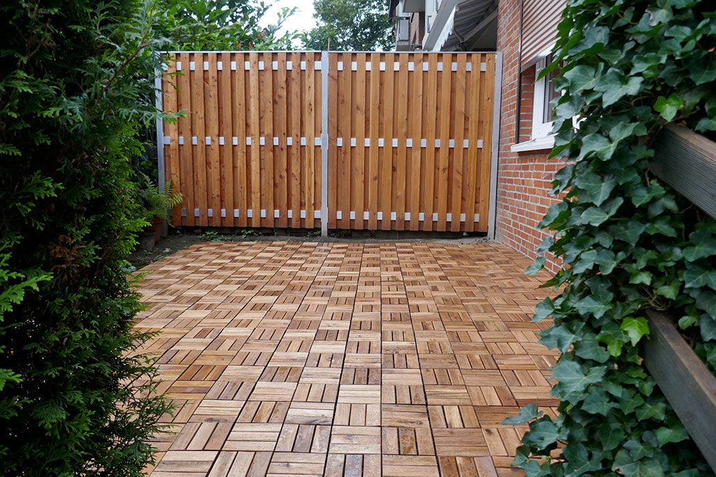 Wooden partition and wooden tiles, two white garden chairs