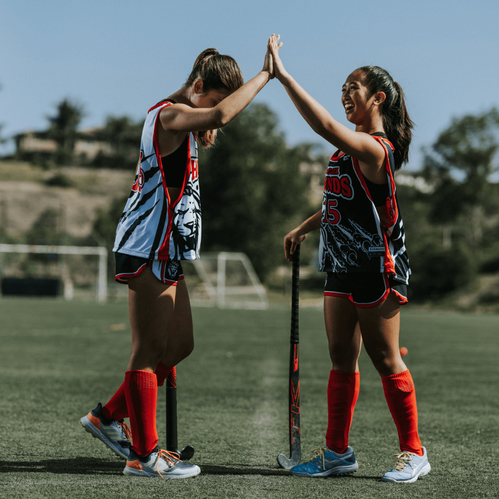 Teammates celebrate at a youth lacrosse game.